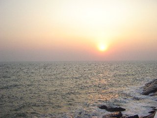 arancione tenue in cielo per tramonto sul mare