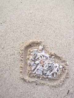 sassolini dentro cuore su spiaggia