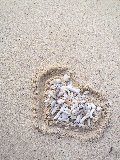 sassolini dentro cuore su spiaggia