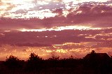 cielo immenso rossastro al tramonto oltre la campagna